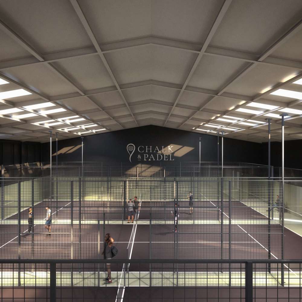 Looking across Padel courts from up high, with the Chalk & Padel logo on the wall in the background