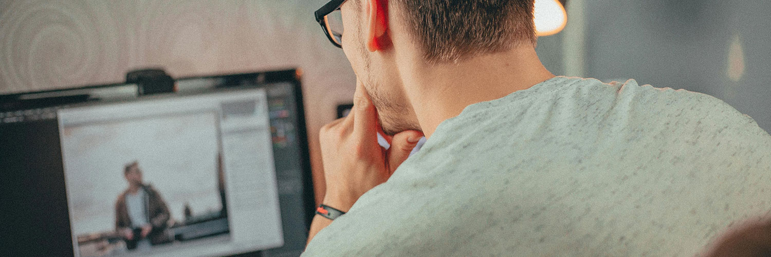 close up photo of a man working in front of a computer